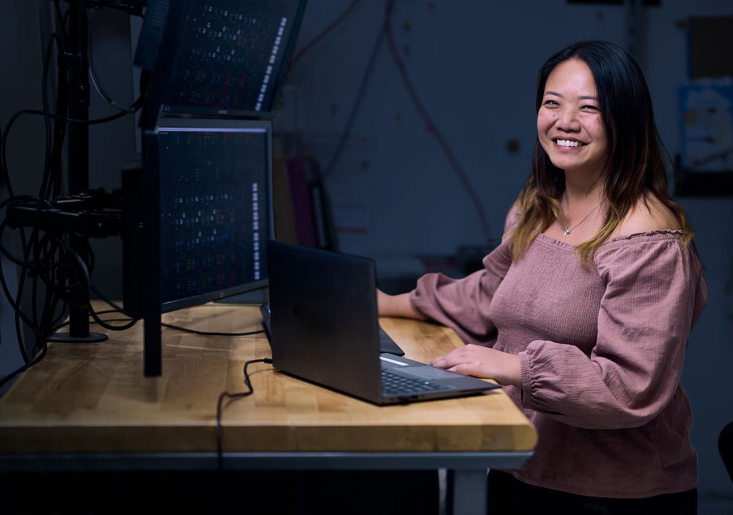 Woman at a desk with many monitors