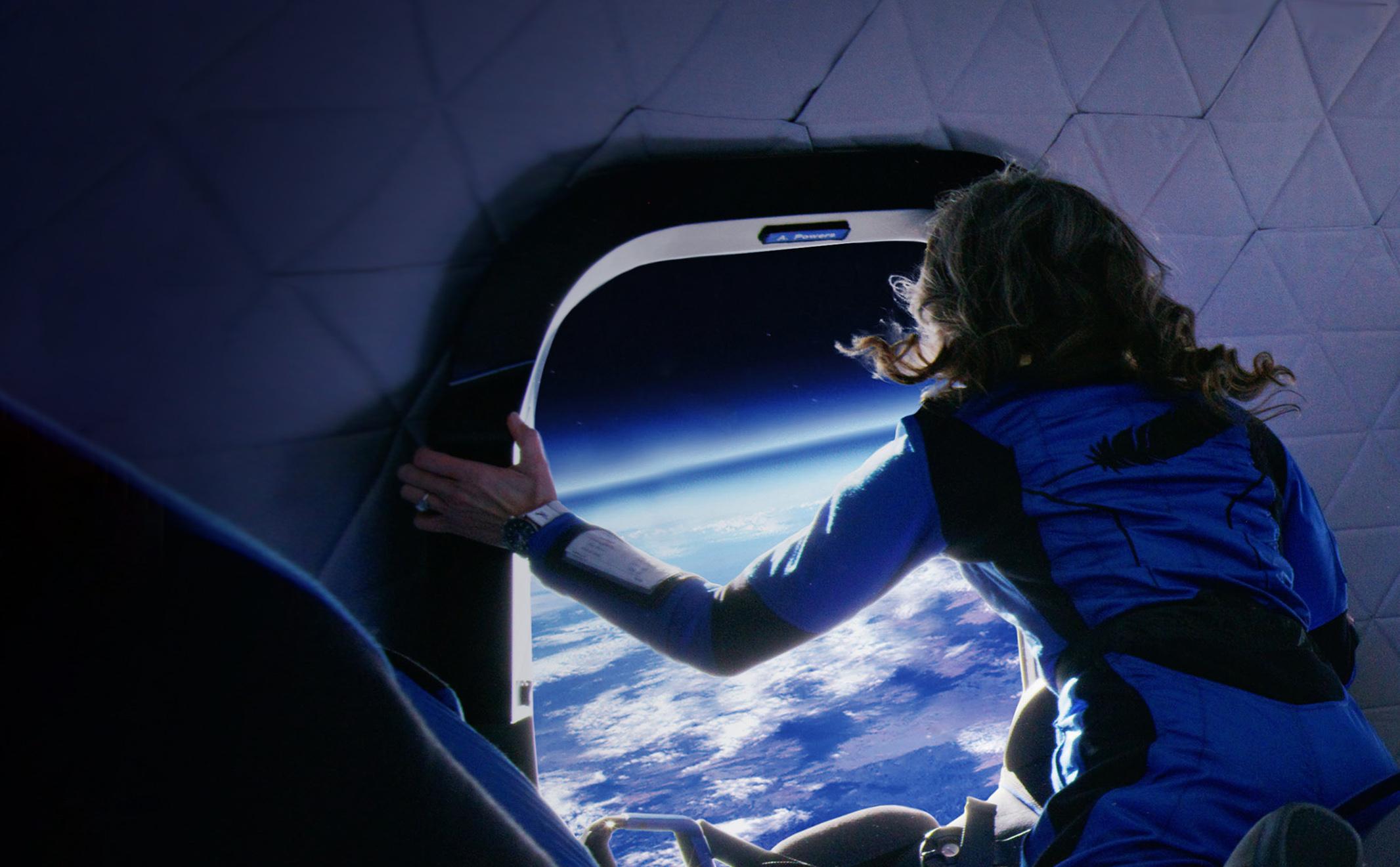 An astronaut floats weightless in New Shepard's crew capsule while looking out the window at Earth.