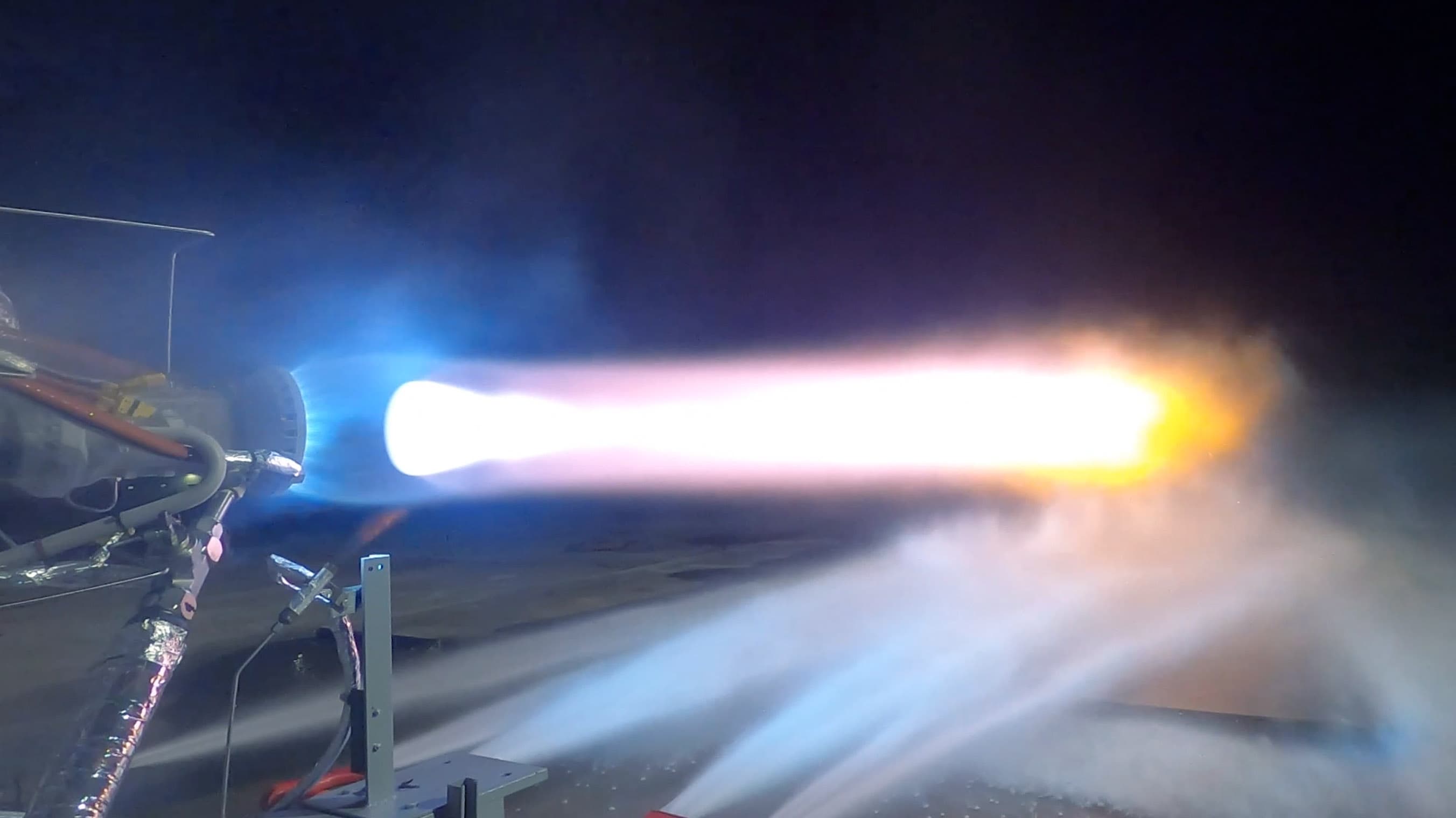 The bright flame from a BE-7 hotfire at night.