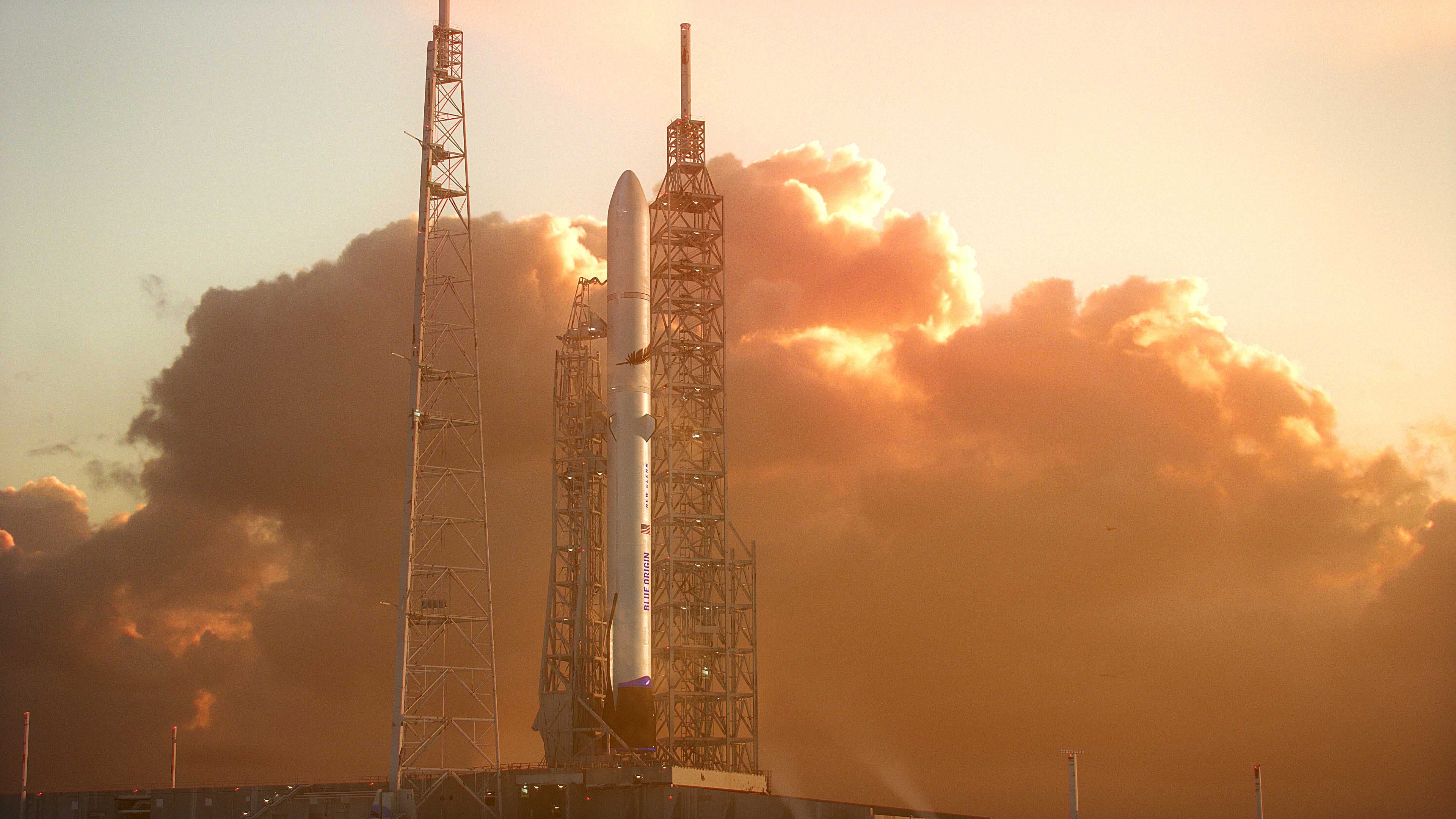 The rendering shows the orbital launch vehicle in between several metal towers against a backdrop of billowy brown and orange clouds.