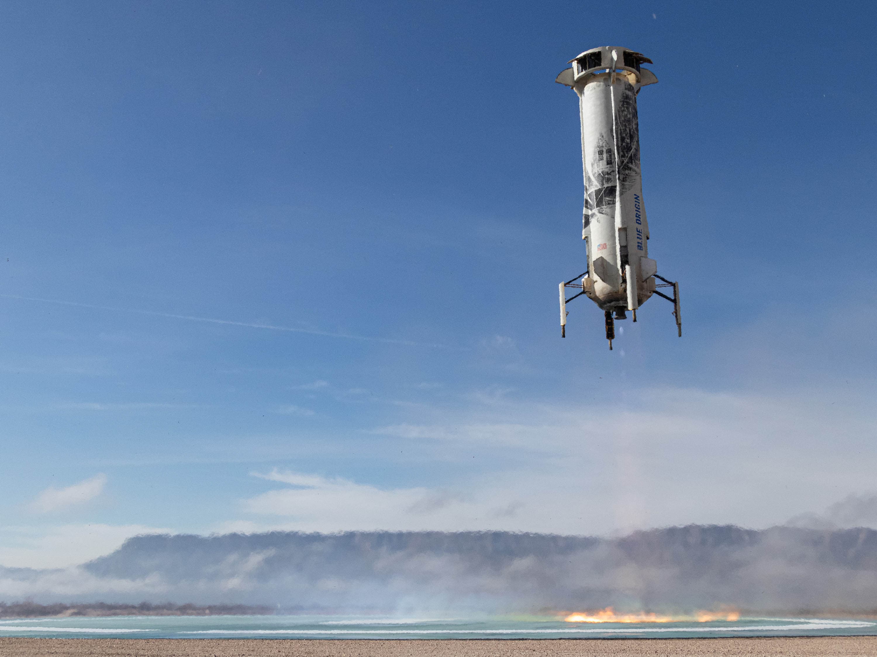 The New Shepard booster descends onto the landing pad.