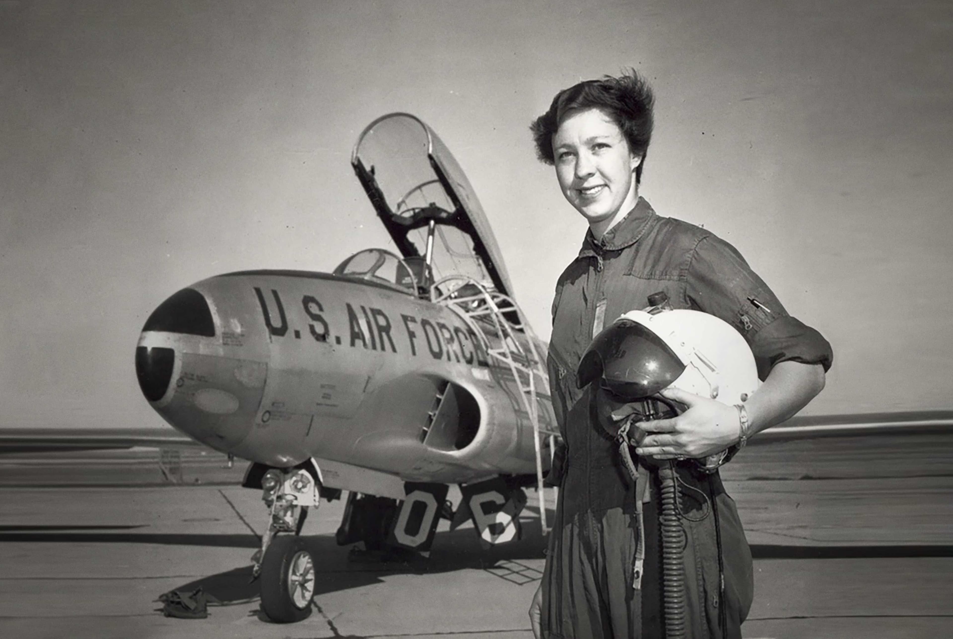 Aviation pioneer Wally Funk as a young pilot standing in front of a U.S. Air Force plane.