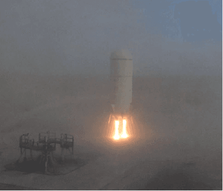 Goddard, the first development vehicle in the New Shepard program, expels fiery exhaust and smoke as it descends.