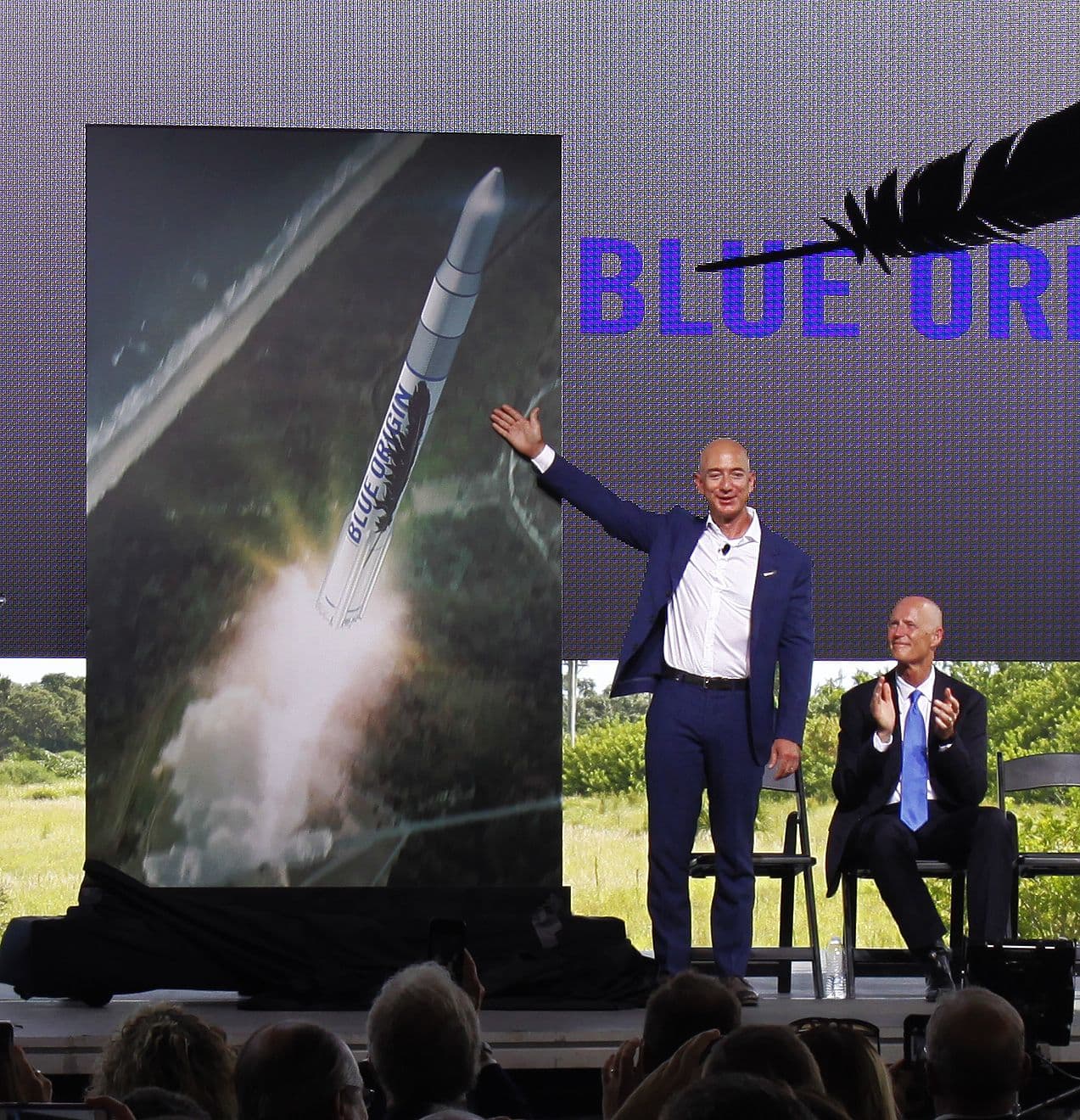 Jeff Bezos points to an illustration of a future Blue Origin orbital vehicle launching from the Space Coast in Florida.