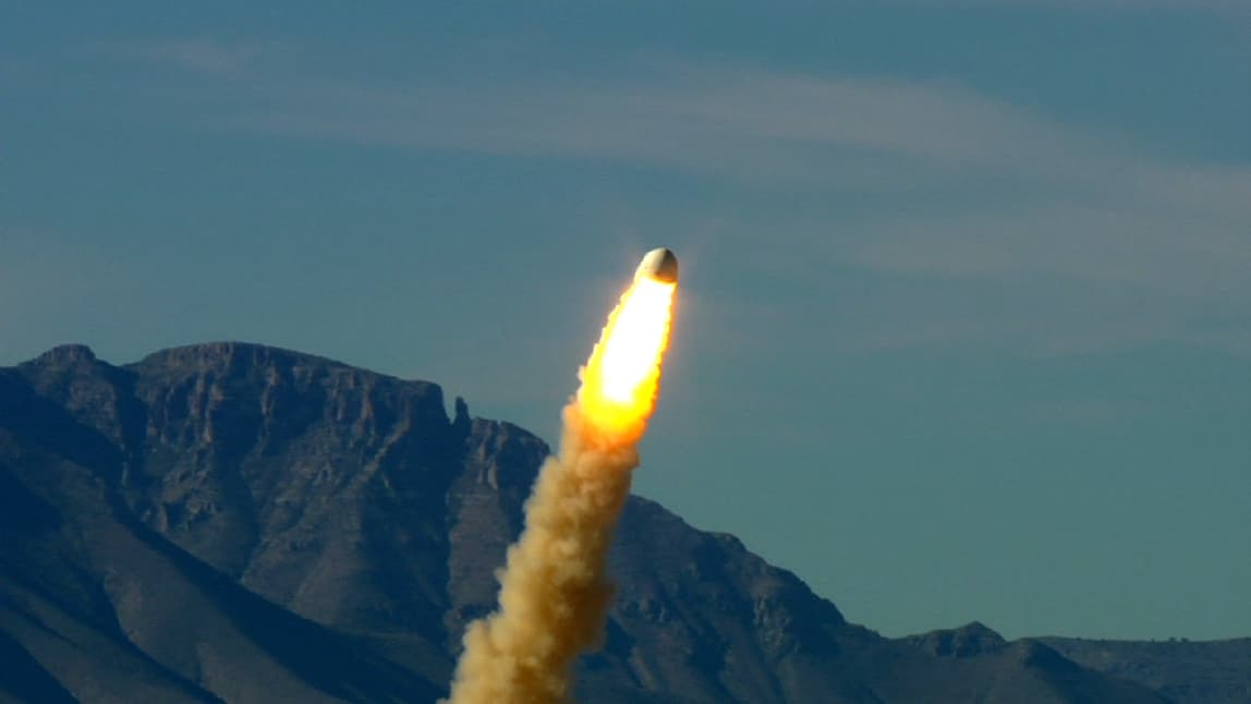 The engine fires on the New Shepard crew capsule during its first successful pad escape test.