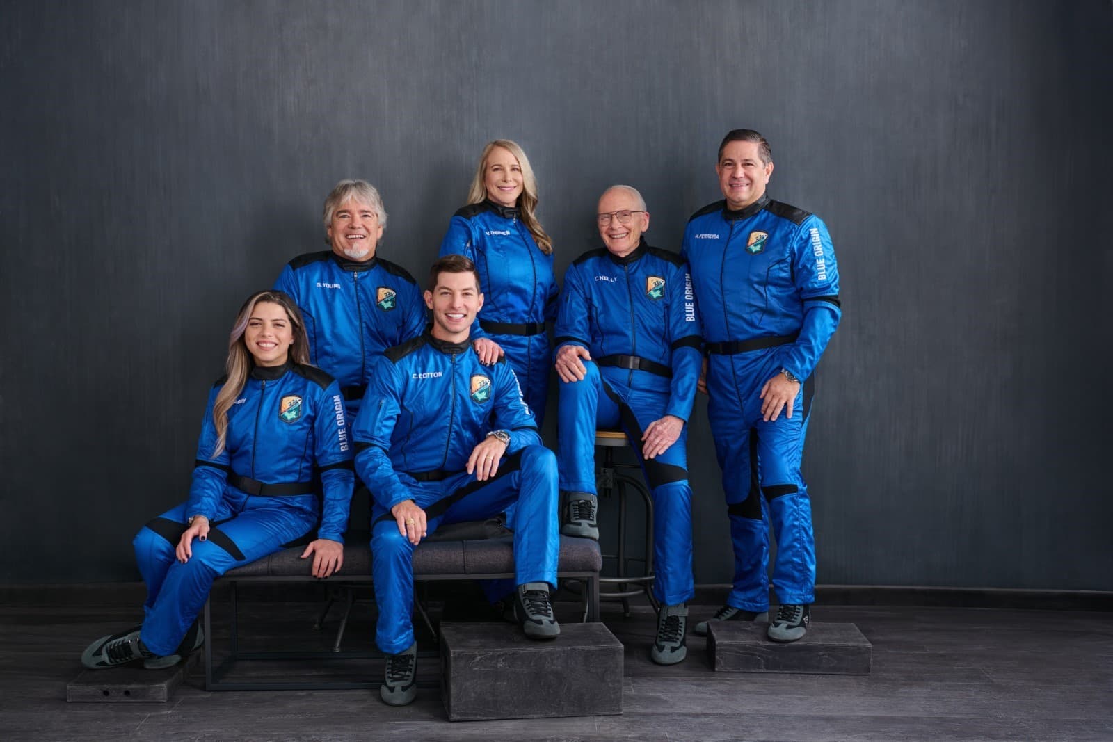 The NS-22 crew poses for their official portrait wearing blue flight suits.