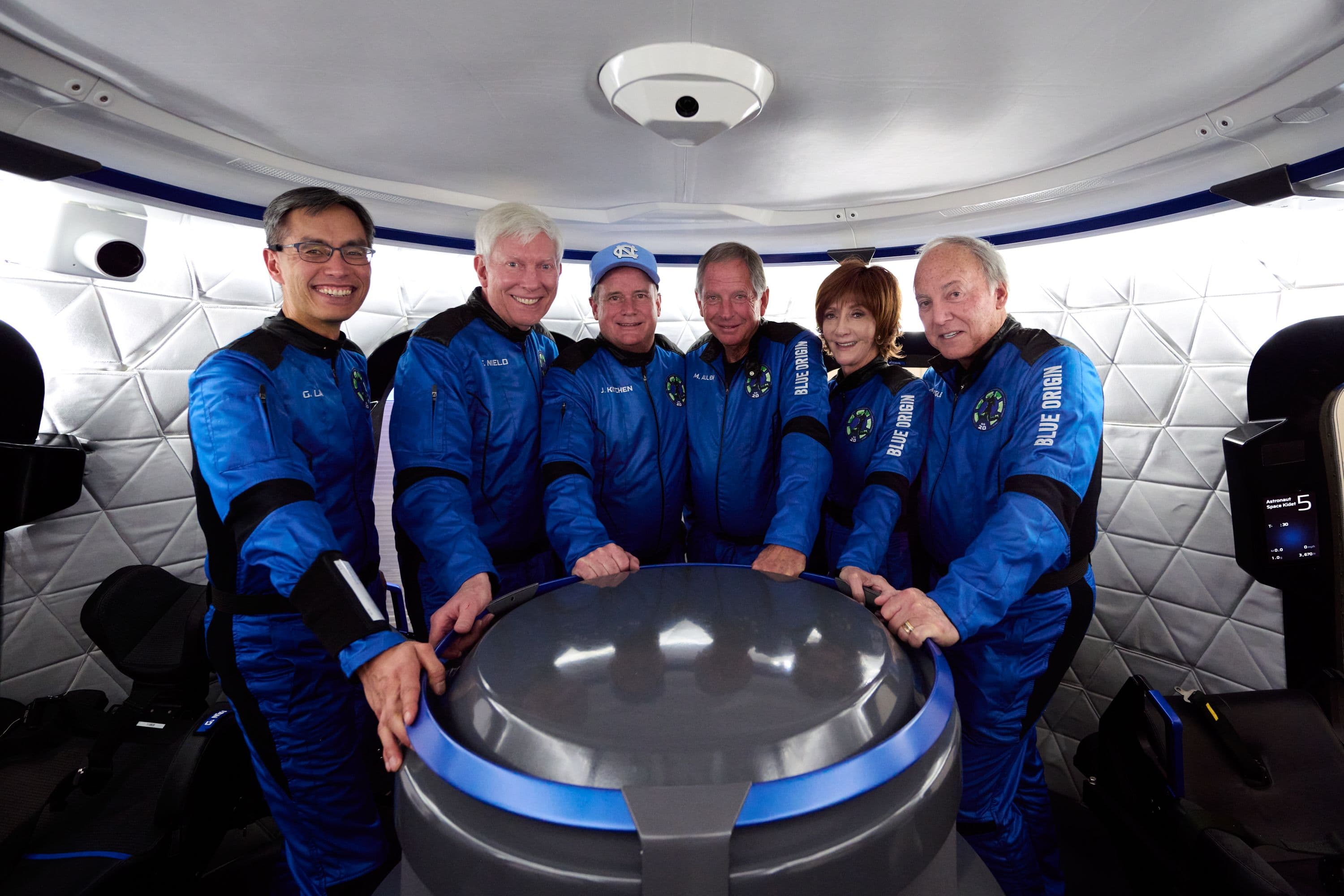 The NS-20 crew poses inside the crew capsule mock-up in the Astronaut Training Center.